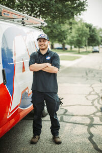 technician-standing-beside-van-with-arms-folded